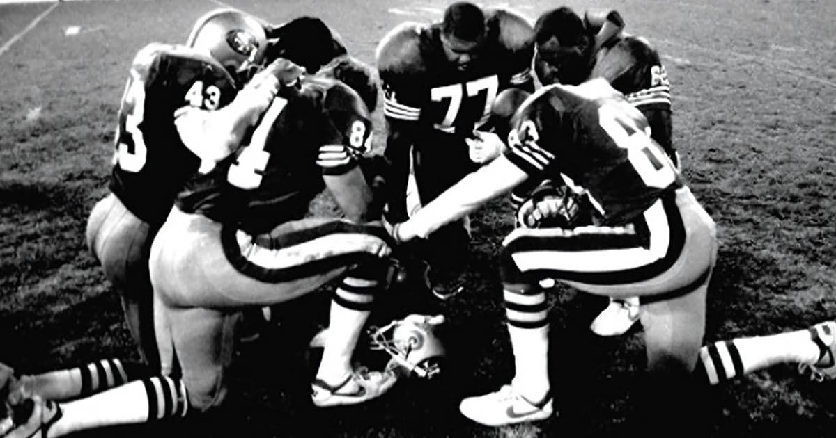 NFL players in postgame prayer circle on the field